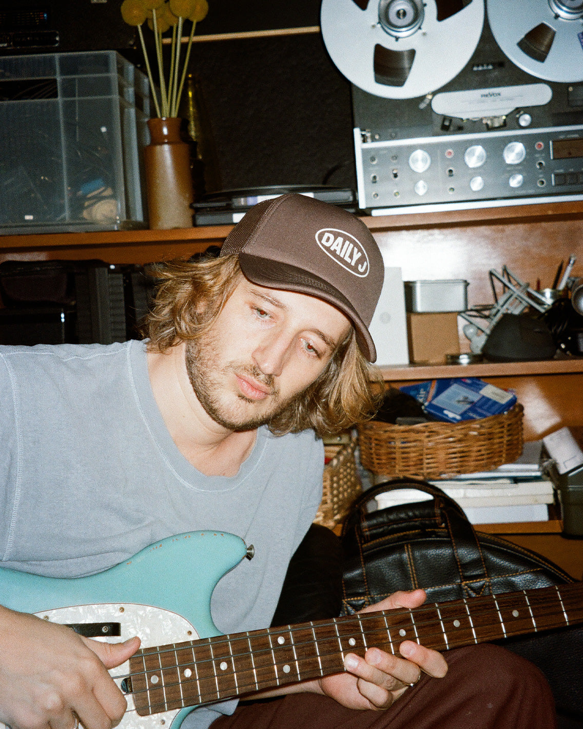 Person playing guitar in a room with vintage equipment
